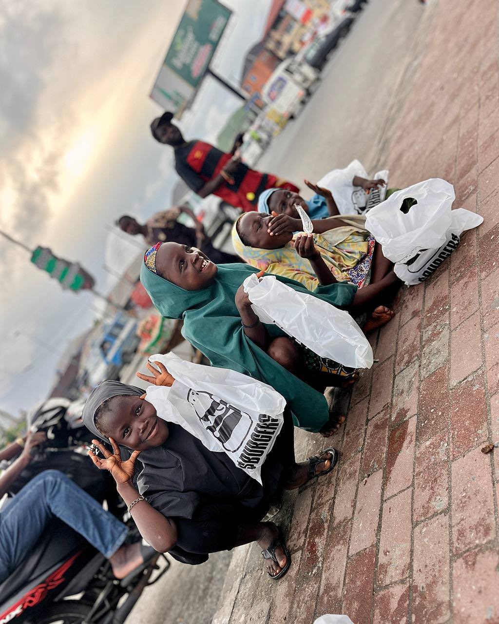 Children holding $BURGERS meal bags, smiling