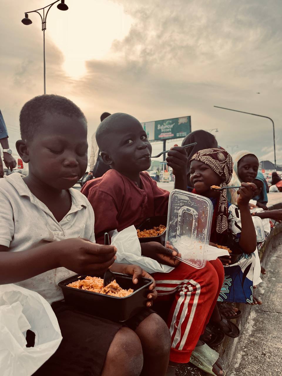 Children eating meals together at sunset